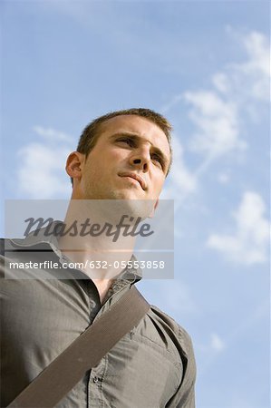 Man outdoors, looking away, low angle view