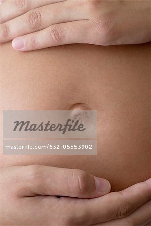 Close-up of woman's hands on pregnant belly