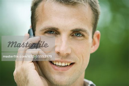 Man using cell phone outdoors, portrait