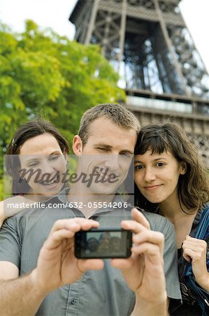 Friends posing for picture in front of Eiffel Tower, Paris, France