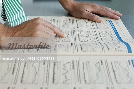 Man reading finance section of newspaper