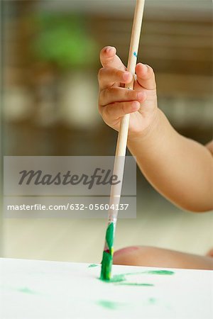 Child's hand holding paintbrush