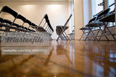 Folding chairs lined up in empty conference room