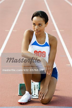 Female runner crouched at starting line