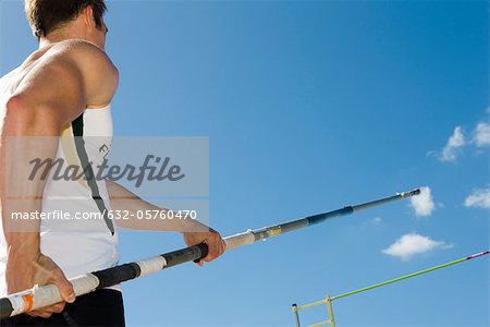 Athlete preparing for pole vault, low angle view