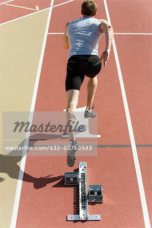 Man running on track, rear view