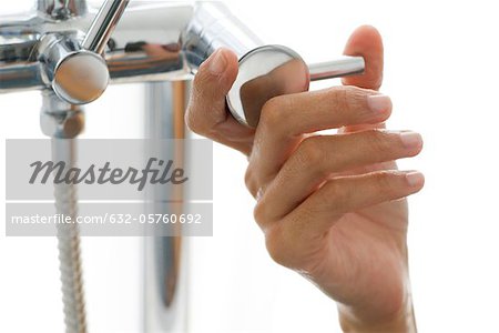 Woman's hand turning faucet