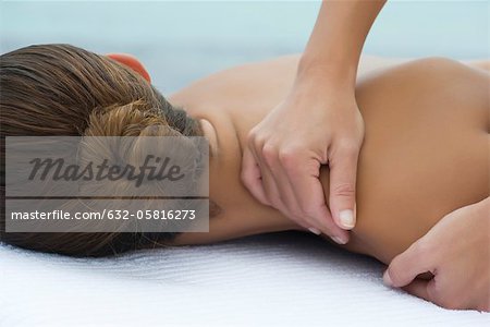 Massage therapist giving woman massage, close-up
