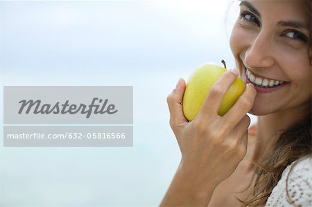Woman eating apple, portrait