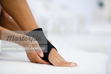 Woman wearing ankle brace, low section