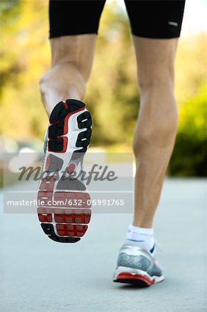 Man jogging, low section, rear view