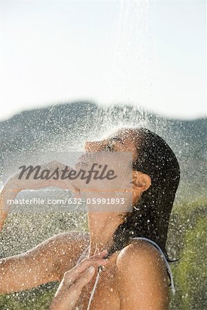 Mid-adult woman showering outdoors