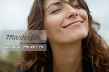 Smiling young woman with eyes closed Stock Photo Masterfile