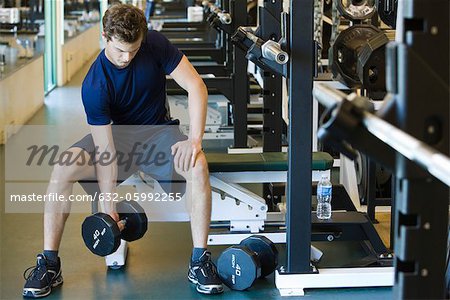 Young man lifting dubmbell