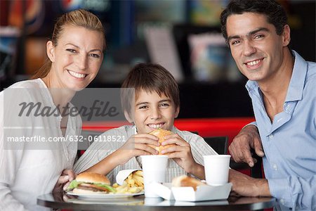 Family eating together in fast food restaurant, portrait