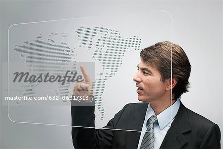 Businessman using advanced touch screen technology to view world map