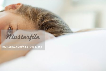 Woman lying down, looking at camera, cropped