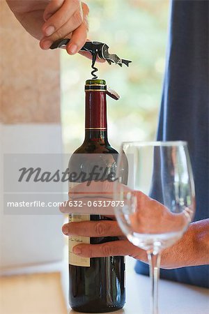 Man uncorking bottle of wine, cropped