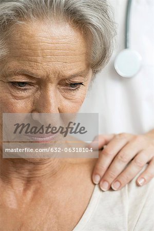 Senior woman receiving bad news from caring doctor, cropped