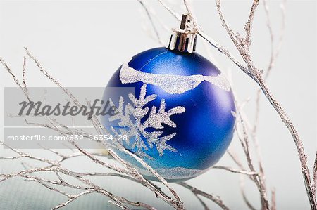Blue bauble hanging from silver branches