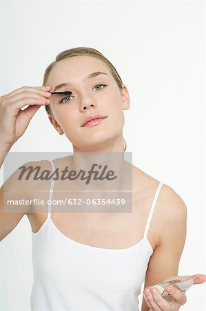 Preteen girl putting on eye shadow