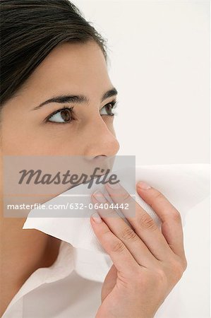 Young woman wiping mouth with napkin