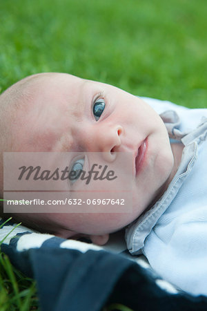 Baby boy lying on grass, portrait