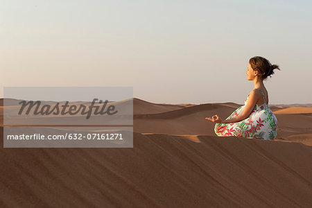 Girl meditating in desert