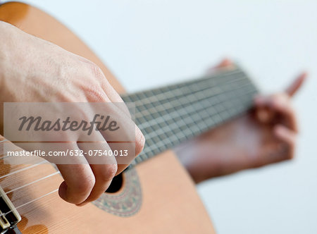 Musician playing acoustic guitar, close-up