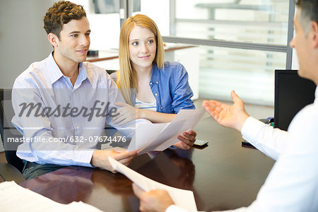 Couple discussing paperwork with advisor