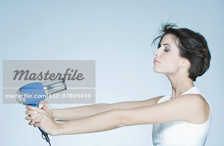 Woman holding out hair dryer, profile
