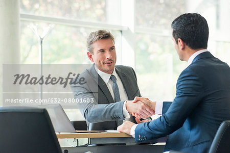 Businessmen shaking hands in meeting