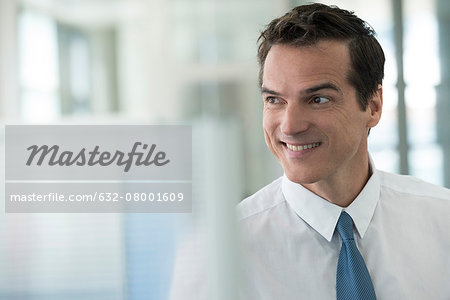 Businessman looking away, smiling, portrait