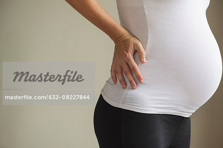 Pregnant woman massaging lower back