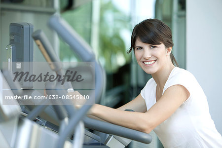 Woman working out in health club, smiling cheerfully