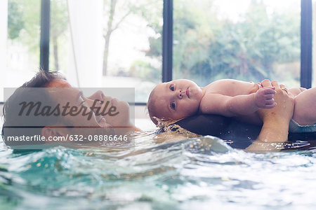 Parents with infant in swimming pool Parents with infant in swimming pool