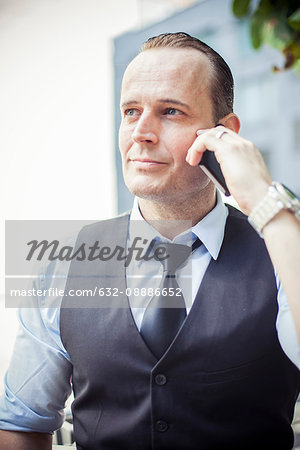 Businessman using cell phone, portrait