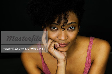 Young woman with hand under chin, portrait