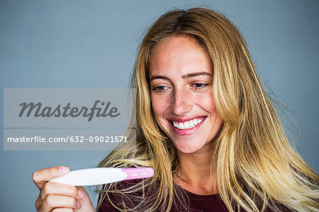 Young woman smiling pregnancy test results