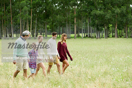 Family taking walk together through field