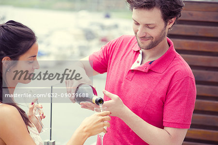 Man pouring glass of champagne for woman