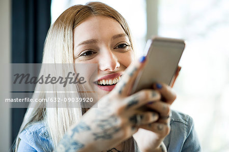 Woman using smartphone and smiling cheerfully