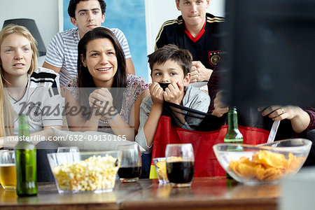 German football fans watching match on TV at home