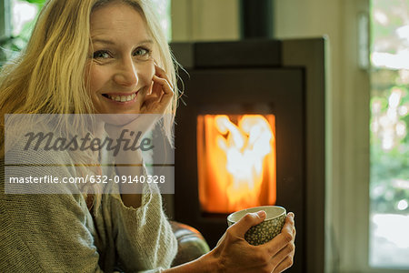 Mature woman relaxing with coffee at home, portrait
