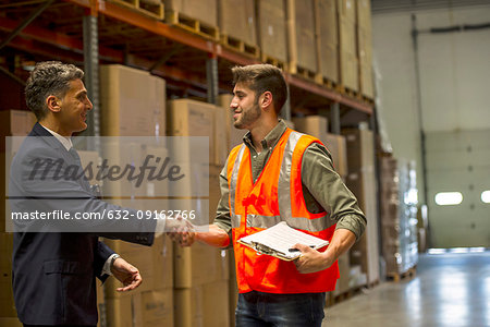 Worker and businessman shaking hands