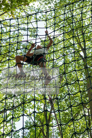 teenage girl climbing on cargo net