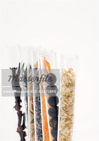 Test tubes containing dried flowers, berries and spices