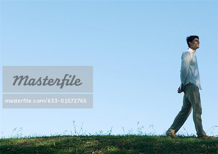 Man walking across grass, low angle view