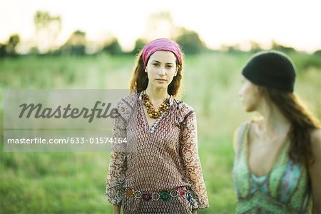 Young hippie women walking in field