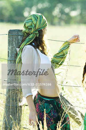 Young hippie woman looking over fence